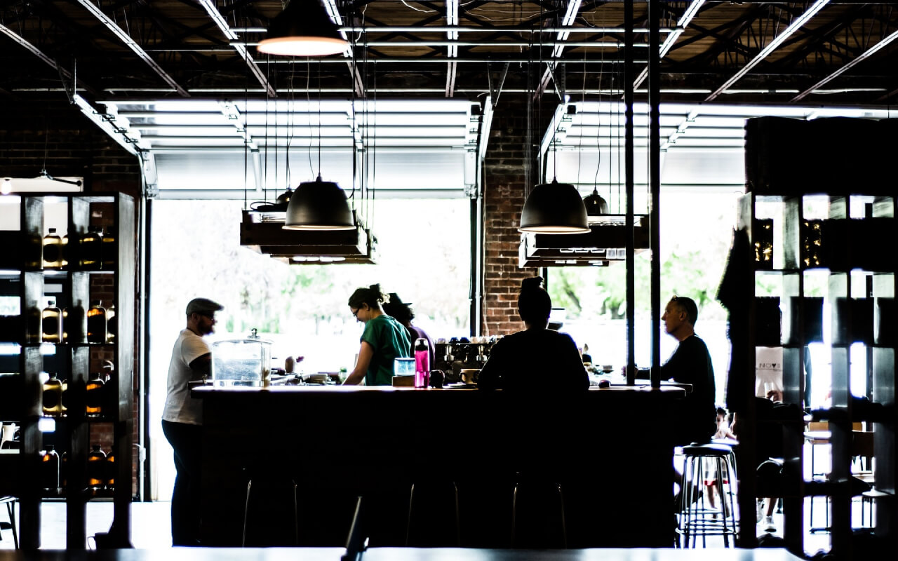 中央にカウンターバーがあり店員が注文を受けている。周りにお客さんが座っている